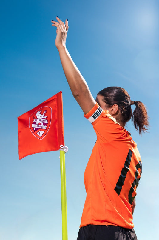 Soccer player standing next to custom corner flag with team logo