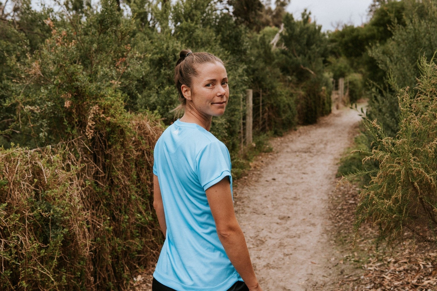 Women's running top in blue with moisture wicking technology made from recycled material.