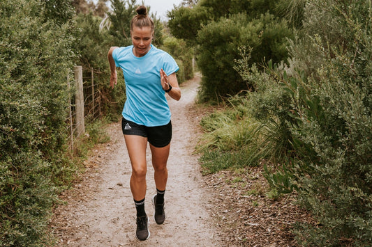 Women's running top in blue with moisture wicking technology made from recycled material.